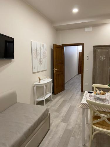a room with a bed and a table and a sink at INFORMIS B&B in Capua