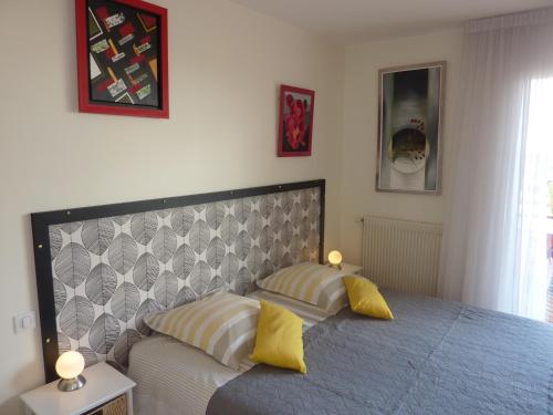 una camera con un letto con due cuscini gialli di Les Terrasses de Bellemoure Cébazat a Cébazat