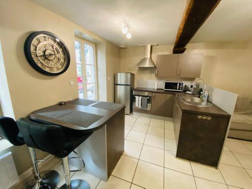 uma cozinha com um balcão e um relógio na parede em Bel appartement cœur de ville em Chalon-sur-Saône