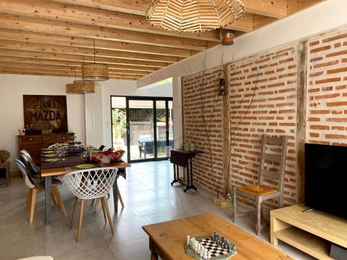 salon ze stołem i ceglaną ścianą w obiekcie Clos De La Charnaille w mieście Cousance