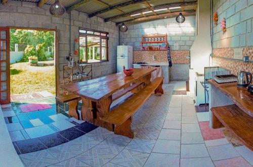 a kitchen with a wooden table and a refrigerator at Lobo Hotel in Garopaba