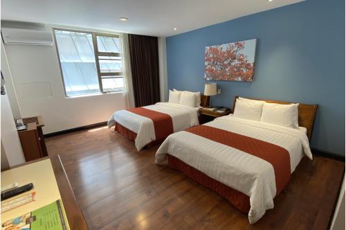 a hotel room with two beds and a window at Balmoral Hotel San José CR, Historic District in San José