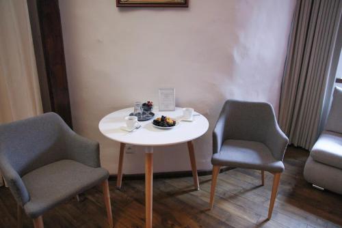 a table with two chairs and a plate of food on it at Hotel Svambersky dum in Český Krumlov