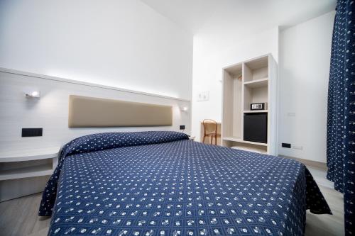 a bedroom with a bed with a blue comforter at Hotel Giotto in Padova