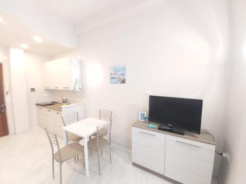 a kitchen with a table and a television on a counter at Casa Mazzini in Alassio