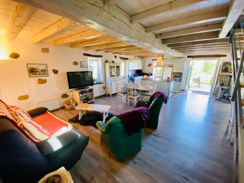 een woonkamer met banken en een tafel en een keuken bij "Palomar", duplex de charme 80m2 - 2 ch - 2 sdb - parking et terrasse in Saint-Jean-de-Luz