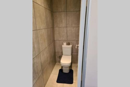 a bathroom with a toilet in a tiled room at Pattys Place 12 Hakbos Street in Kathu