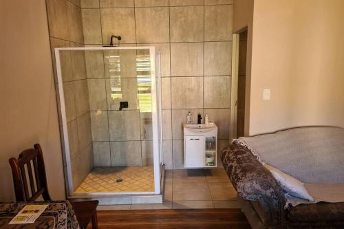 a bedroom with a shower with a bed and a sink at Pattys Place 12 Hakbos Street in Kathu