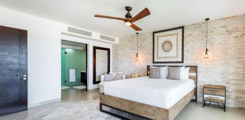 1 dormitorio con cama y pared de ladrillo en Gorgeous Ocean Front Apartment Casa Shell condo, en Playa del Carmen