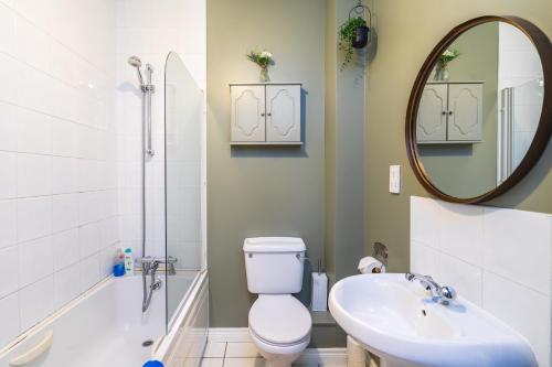 a bathroom with a toilet and a sink and a mirror at Prime Ballycastle Apartment in Ballycastle