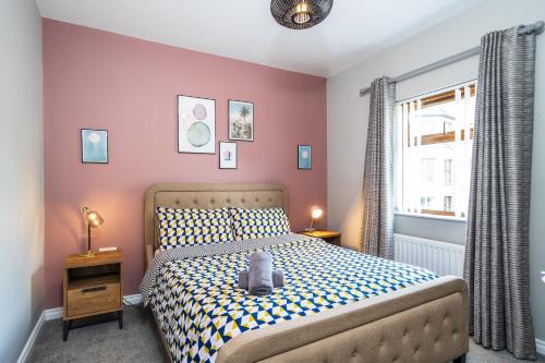 a bedroom with a bed with a teddy bear on it at Prime Ballycastle Apartment in Ballycastle
