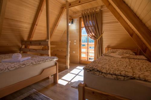 sypialnia z 2 łóżkami w drewnianym domku w obiekcie Arielove kolibe w mieście Mokra Gora