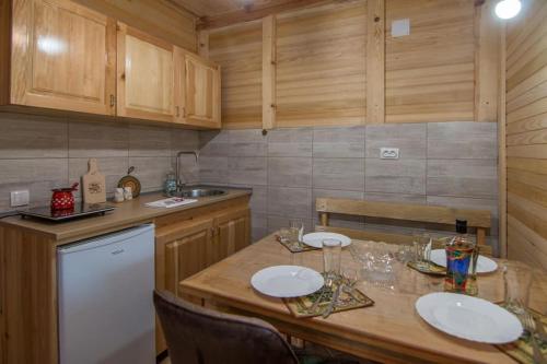 a kitchen with a table with white plates on it at Arielove kolibe in Mokra Gora