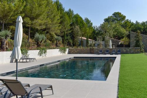 - une piscine dans une cour avec des chaises et un parasol dans l'établissement Domaine de la Galinière, à Châteauneuf-le-Rouge