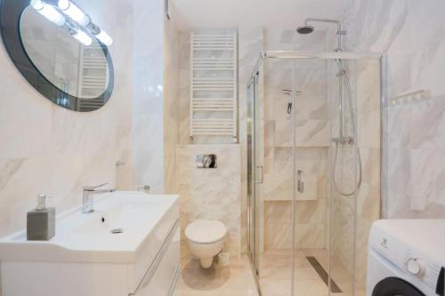 ein Bad mit einer Dusche, einem WC und einem Waschbecken in der Unterkunft Apartament Perłowy in Świnoujście