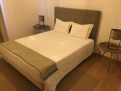 a bed with white sheets and pillows in a room at Quinta da Corga in Prova