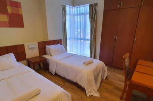 una camera d'albergo con due letti e una finestra di Gateway Suite Cozy Dream Home for Nature Lover 8A a Kuching