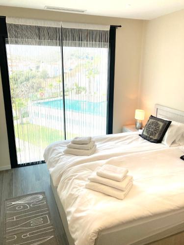 a bedroom with a bed with towels on it at Luxury Penthouse Jacobo - The View Fuengirola in Fuengirola