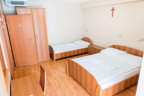 a small room with two beds and a cross on the wall at Villa Marija & Darko in Međugorje