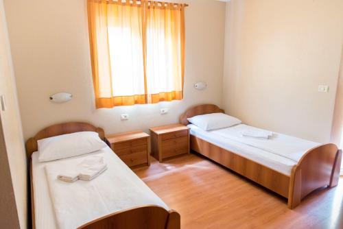 two beds in a small room with a window at Villa Marija & Darko in Međugorje