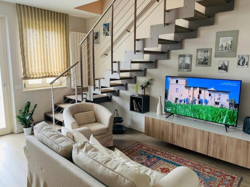 a living room with a tv and a staircase at CB House Tuscany in Pietrasanta