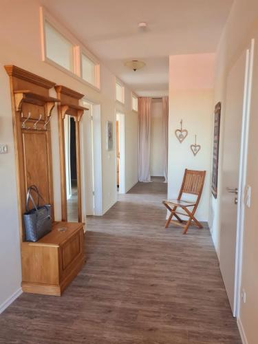 a hallway of a home with a chair and a table at Ferienwohnung Kaiserblick in Grassau