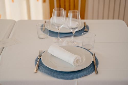 a table with a white plate and wine glasses at Luxmar Apartaments in Benidorm