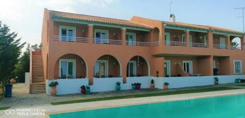 a house with a swimming pool in front of it at Sausan Hotel in Sidari