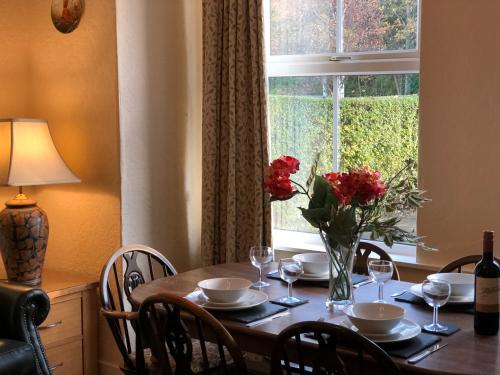 a table with a vase of flowers and a window at Formby Guest House in Formby