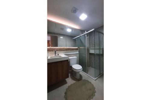 La salle de bains est pourvue de toilettes et d'une douche en verre. dans l'établissement Apartamento lindo de viver no Maurício de Nassau, à Caruaru