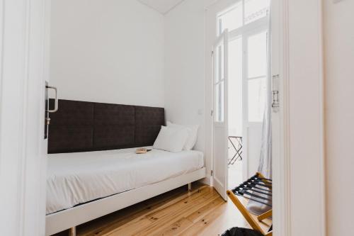a small bedroom with a bed and a mirror at Jaca Hostel Funchal in Funchal