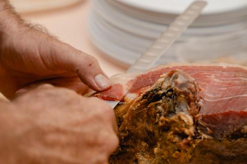 a person cutting a piece of meat with a knife at Luxmar Apartaments in Benidorm