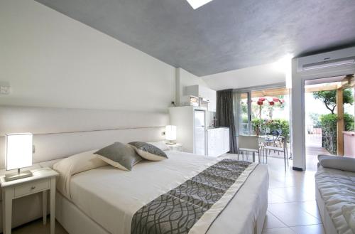 sypialnia z dużym łóżkiem i balkonem w obiekcie Villa Giada Resort w mieście Imperia