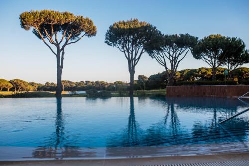 two trees sitting in the middle of a pond at Onyria Quinta da Marinha Hotel in Cascais