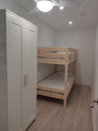 um quarto com um armário e um beliche em Casita en la Playa planta baja de adosado em Castellón de la Plana