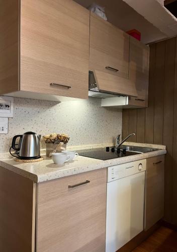 a kitchen with wooden cabinets and a counter top at Appartamento Francesca in Marilleva