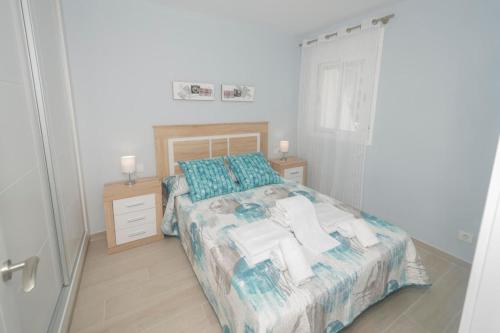 um quarto com uma cama com almofadas azuis em Aguamarina 57b em Calpe