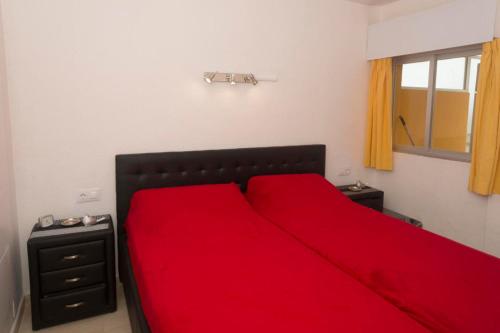 a bedroom with a red bed with a red blanket at Voramar 26b in Calpe
