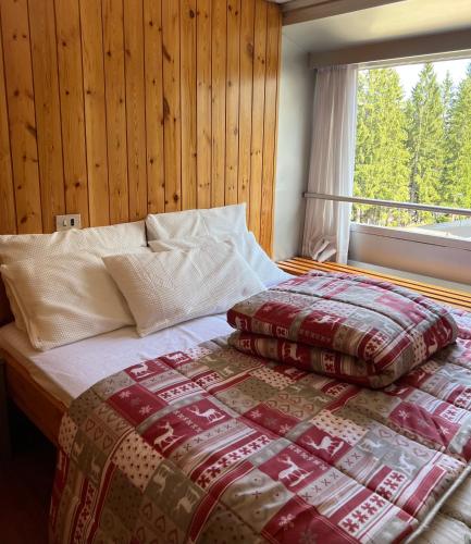 a bed with two pillows on it in front of a window at Appartamento Francesca in Marilleva