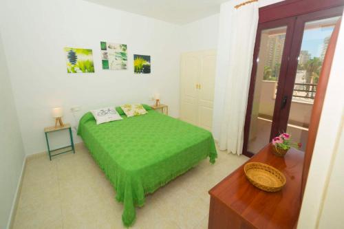1 dormitorio con 1 cama verde en una habitación en Zafiro 32b, en Calpe