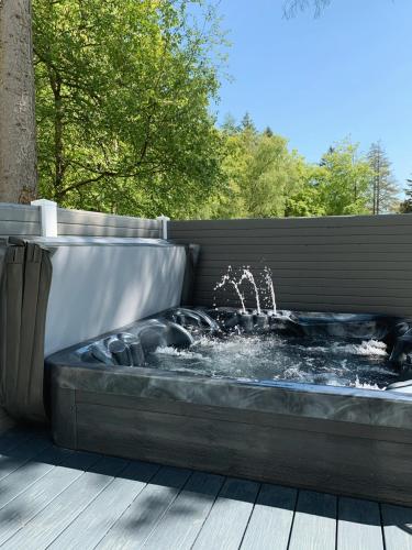 a hot tub with a fountain on a deck at Percy Wood Lodges with Hot Tubs in Swarland