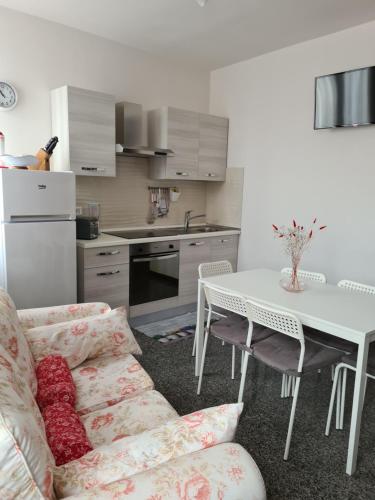 ein Wohnzimmer mit einem Sofa und einem Tisch sowie eine Küche in der Unterkunft Appartamento luminosissimo in pieno centro in Grosseto