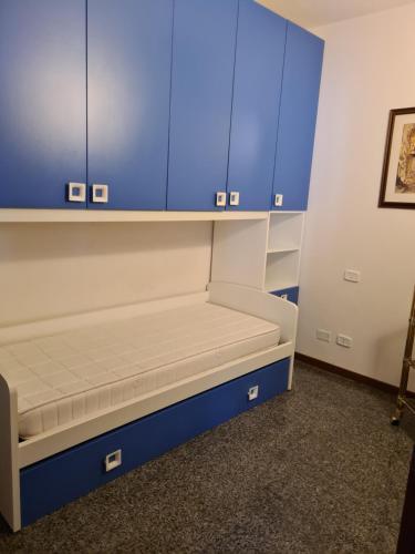 Zimmer mit einem Bett mit blauen Schränken in der Unterkunft Appartamento luminosissimo in pieno centro in Grosseto