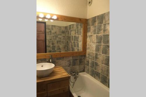 bagno con lavandino, vasca e specchio di Charmant appartement, centre ville, vue Mont-Blanc a Chamonix-Mont-Blanc