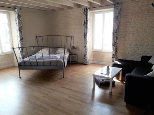 a living room with a bed and a couch at Le Marais Picotin in Saint-Pierre-le-Vieux