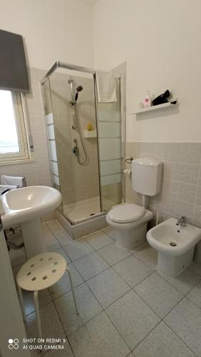 a bathroom with a shower and a toilet and a sink at Fontanarossa Airport Apartment in Catania