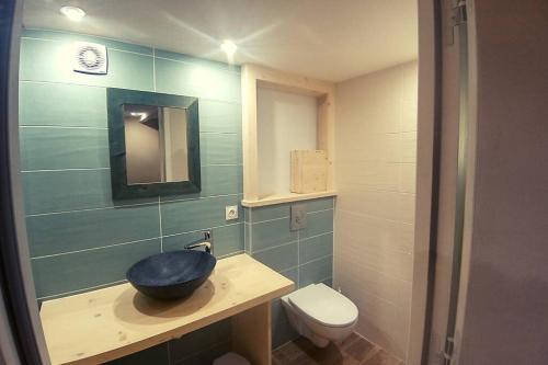 a bathroom with a bowl sink and a toilet at Les berges du Doron in Planay