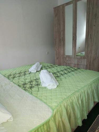 ein Schlafzimmer mit einem grünen Bett und Handtüchern darauf in der Unterkunft Stan na dan -Uzun Mirkova in Valjevo
