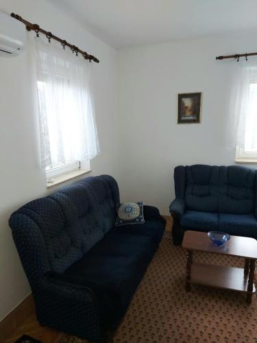 a living room with two blue couches and a table at Stan na dan -Uzun Mirkova in Valjevo