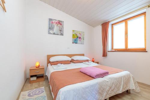um quarto com uma cama e uma janela em Apartments Sveti Leonard em Oprtalj